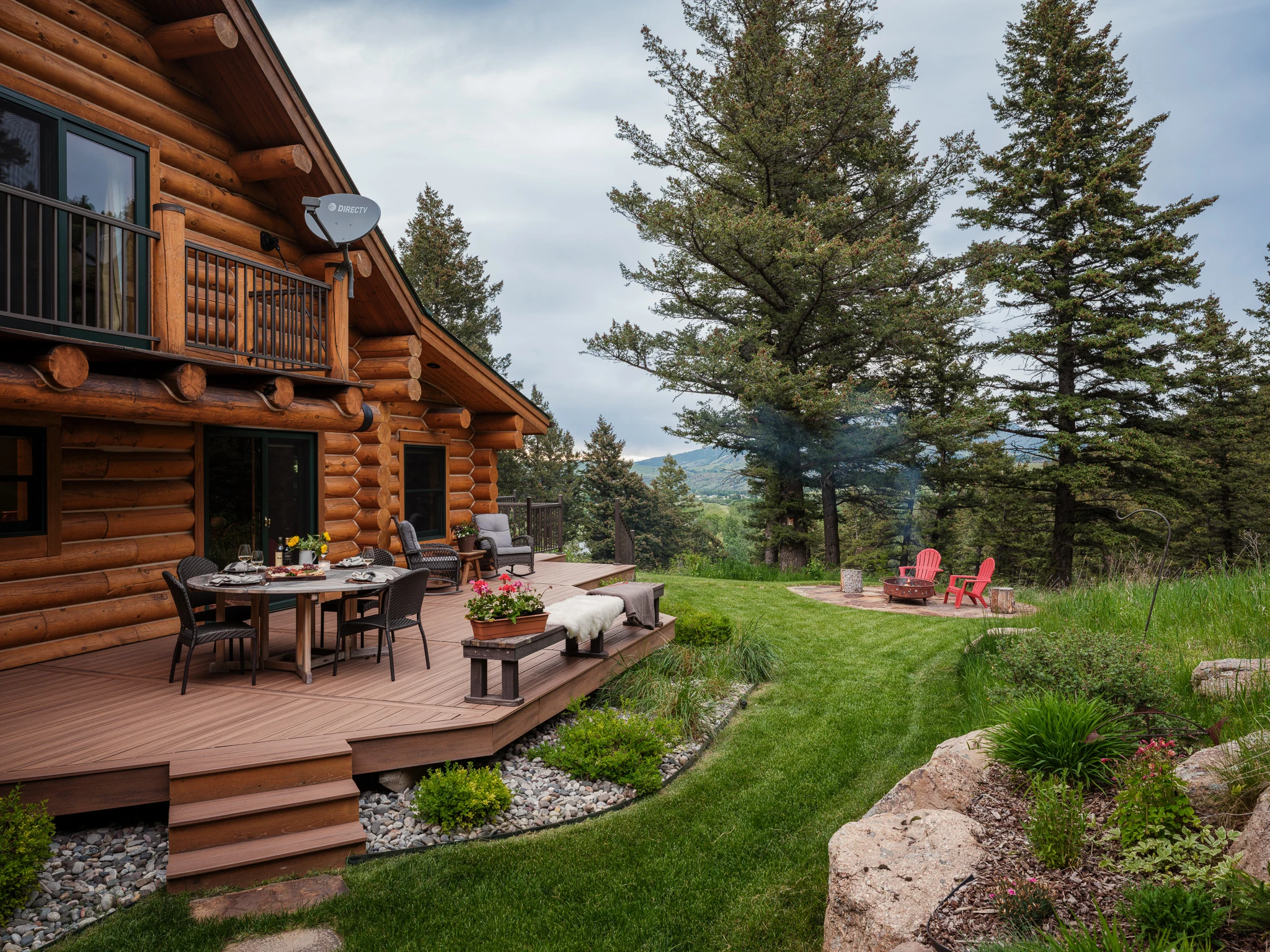 Log home exterior deck and patio with a fire pit and lawn — architectural photography Livingston Montana, Sam Schlauch Designs
